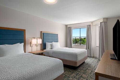 pokój hotelowy z 2 łóżkami i telewizorem w obiekcie Homewood Suites by Hilton West Palm Beach w mieście West Palm Beach