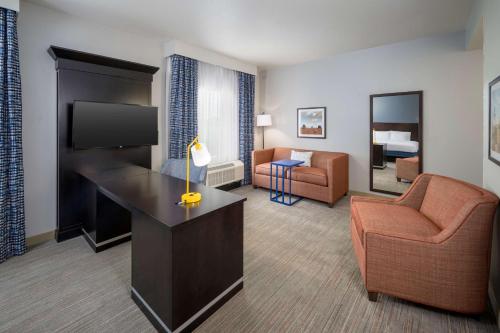 a hotel room with a couch chair and a television at Hampton Inn & Suites Phoenix North/Happy Valley in Phoenix