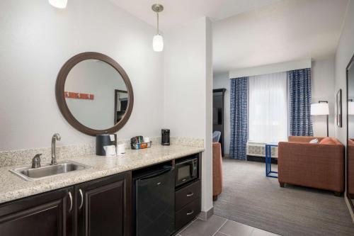 Hampton Inn & Suites Phoenix North/Happy Valley في فينكس: مطبخ وغرفة معيشة مع حوض ومرآة