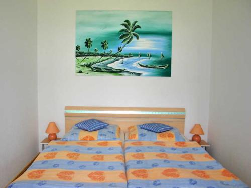 a bedroom with two beds and a painting on the wall at Ferienwohnungen direkt am See in Ventschow