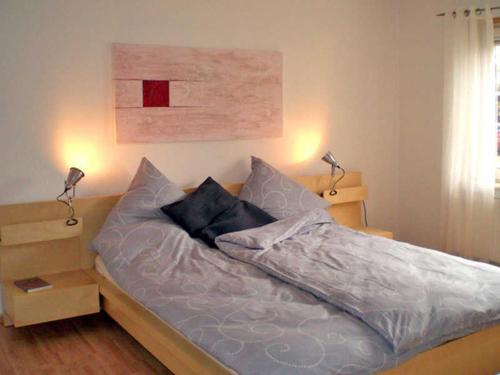 ein Schlafzimmer mit einem Bett mit zwei Lampen in der Unterkunft Ferienwohnung Paul in der Rostocker Heide in Blankenhagen