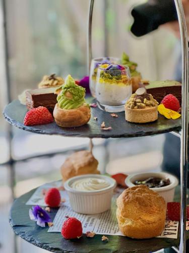 a three tiered plate with pastries and desserts on it at Paradox Sydney in Sydney