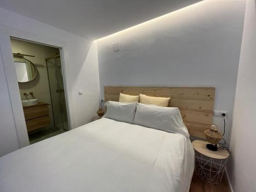 a bedroom with a large white bed and a bathroom at Villa Jontoya in Jaén