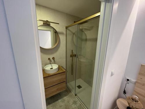 uma casa de banho com um chuveiro, um lavatório e um espelho. em Apartamento jontoya1 em Jaén