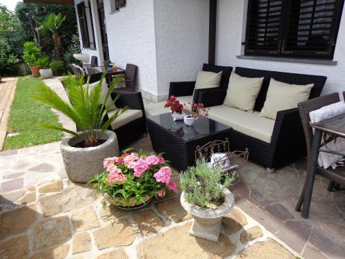 a patio with a couch and some potted plants at Apartments Butinar Pri Kapitanu in Ankaran