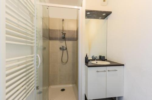 une salle de bain blanche avec une douche et un lavabo dans l'établissement Ilot Verde - Premiere conciergerie, à Montpellier