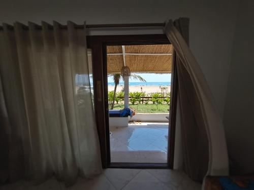 a door to a room with a view of the ocean at Casa do Índico in Praia do Tofo