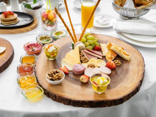 a plate of food on a table with cheese and fruit at Wirgan Hotel Al Nour in Makkah