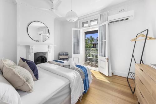 a white bedroom with a bed and a mirror at BRID112G - Urban Serenity in Sydney