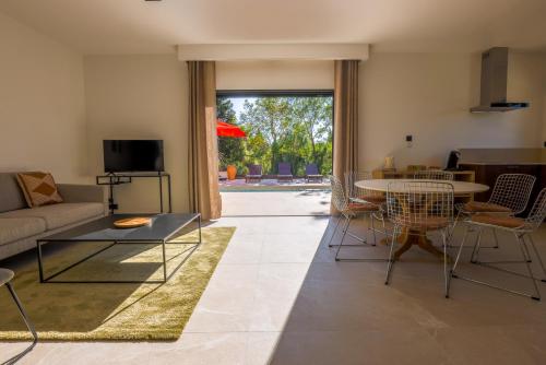 un salon avec un canapé, une table et des chaises dans l'établissement Villa st Francois Piscine privée chauffée ,clim ,parking gratuit, à Carcassonne