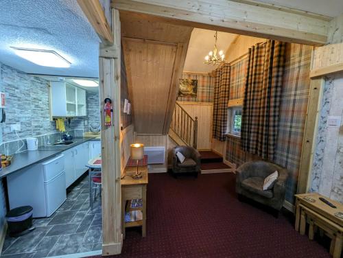 ドラムナドロッキットにあるThe Steading Highland Glen Lodgeのキッチン(椅子2脚、テーブル付)