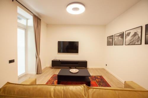una sala de estar con un sofá y una mesa en Cozy apartment in the old town of Klaipėda on the first floor with free parking, en Klaipėda