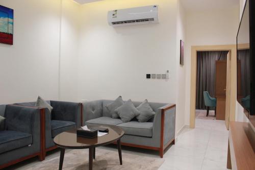 uma sala de estar com um sofá e uma mesa em Five Season Hotel em Al Khobar