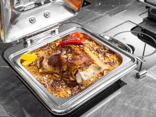 a pan filled with food on a stove at Wirgan Hotel Al Nour in Makkah