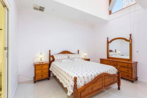 1 dormitorio con cama de madera y espejo en Tuggeranong Short Stay #06C - Sleeps 6 en Canberra