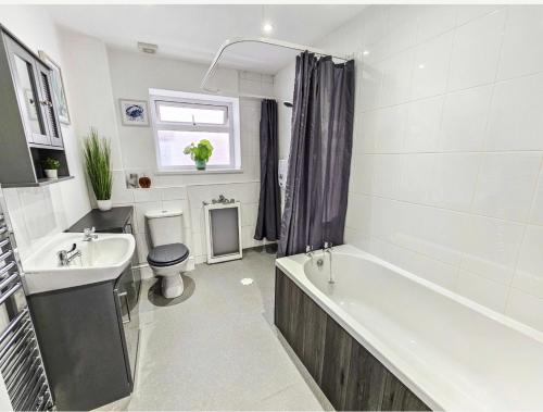 ein Badezimmer mit einer Badewanne, einem WC und einem Waschbecken in der Unterkunft Southdown Road close to Plymouth Argyle FC in Plymouth