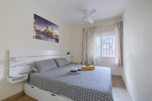 a bedroom with a bed and a window with a clock at Patio Andaluz a 100 metros de la playa in Fuengirola