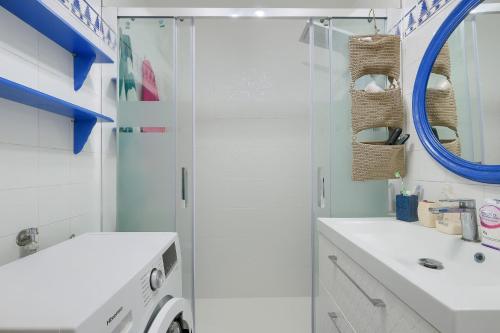 a white bathroom with a sink and a shower at Patio Andaluz a 100 metros de la playa in Fuengirola