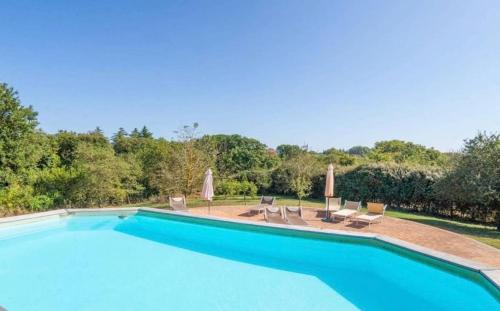 - une piscine avec des chaises longues et des parasols dans l'établissement Villa Profumo, à Campagnano di Roma