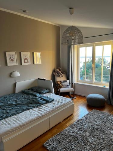 a bedroom with a bed and a large window at Panoramahaus am Ammersee I Sauna I Wellness I Kamin in Herrsching am Ammersee