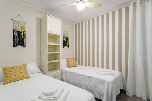 1 dormitorio con 2 camas y ventilador de techo en Peixe Frito Apartment, en Pontevedra