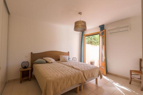 une chambre avec un lit et une grande fenêtre dans l'établissement MAISON MITOYENNE VUE MER WIFI PROCHE L'ILE ROUSSE, à Belgodère