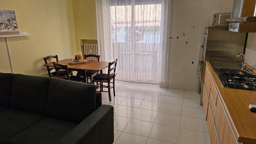 a living room with a couch and a table in a kitchen at Bridge's House - a 50 mt dalla spiaggia e da tutti i servizi! in Pescara