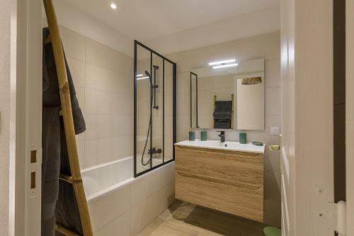 une salle de bain avec une baignoire, un lavabo et une douche dans l'établissement MAISON MITOYENNE VUE MER WIFI PROCHE L'ILE ROUSSE, à Belgodère