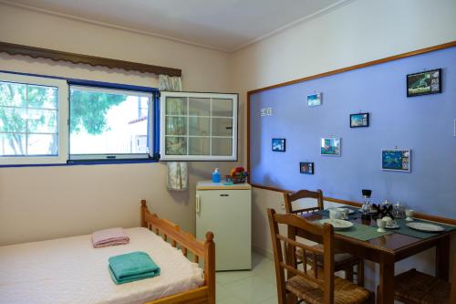 Zimmer mit einem Bett, einem Tisch und einem Fenster in der Unterkunft Liakos' Apartments in Vasiliká