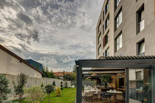 a patio with a table and chairs and a building at Hotel Vibre in Cluj-Napoca