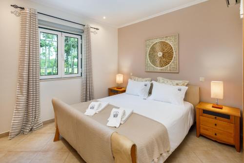 um quarto com uma cama grande com duas toalhas em Falésia Cliff Apartment by The Portuguese Butler em Albufeira