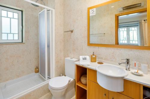 uma casa de banho com um lavatório, um WC e um chuveiro em Falésia Cliff Apartment by The Portuguese Butler em Albufeira