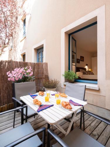 - une table blanche avec de la nourriture et des boissons sur la terrasse dans l'établissement ADELFA - Centre ville - Terrasse, à Nancy