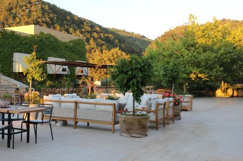 a patio with white couches and tables and trees at Bkerzay in Baakleen