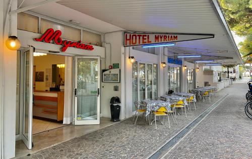 a restaurant with tables and chairs on a street at Hotel Myriam in Lignano Sabbiadoro