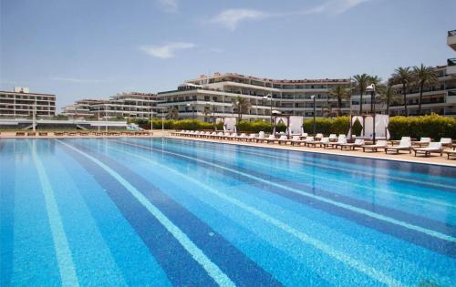 a large swimming pool with chairs and a building at Stunning Sea Front Chalet In Tripoli in Trâblous