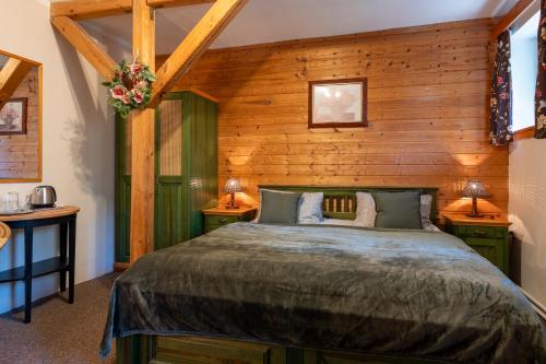 een slaapkamer met een groot bed en houten wanden bij Pension Herta in Horní Maršov