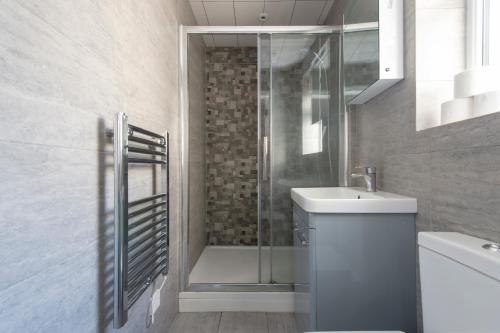 a bathroom with a shower and a toilet and a sink at Fab garden flat central Camden in London