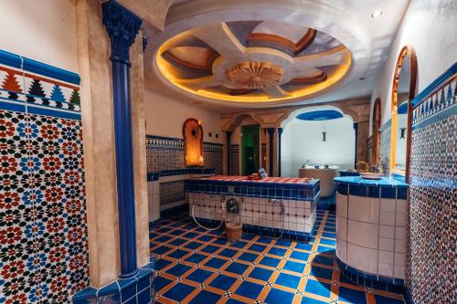 a bathroom with a tub and tiled floors at Trofana Royal 5-Sterne Superior Resort in Ischgl