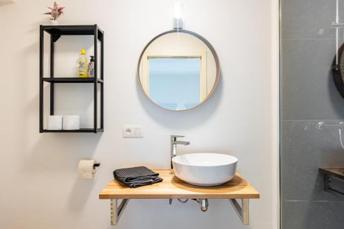 a bathroom with a sink and a mirror on a table at Le Gîtel in Spa
