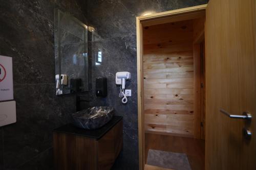 y baño con ducha y pared de madera. en Freskia Resort en Ferizaj