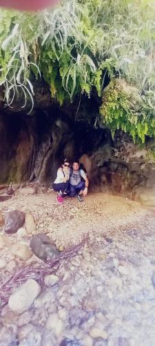 a man and a child sitting in a cave at - Trekking from Dana to Petra in Dana