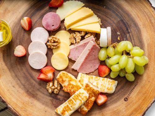a plate of food with cheese grapes and fruit at Wirgan Hotel Al Nour in Makkah