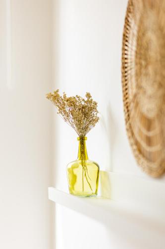a small yellow vase with flowers in it on a shelf at Le Gîtel in Spa