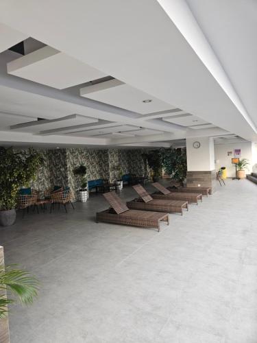 een wachtruimte met banken en planten in een gebouw bij Beststay @Mataramcity yudhistira tower in Kejayan