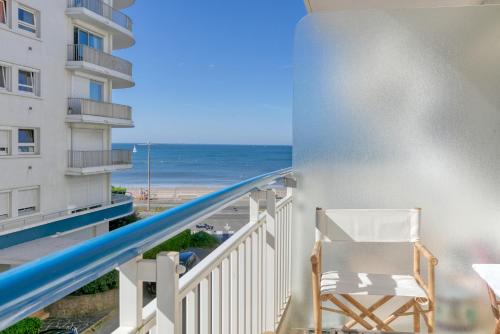 una silla en el balcón con vistas a la playa en Vue sur mer La Baule Riviera, en La Baule