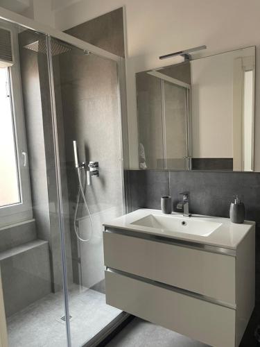 a bathroom with a white sink and a shower at Deluxe Apartment Self Check in Parking in Genova