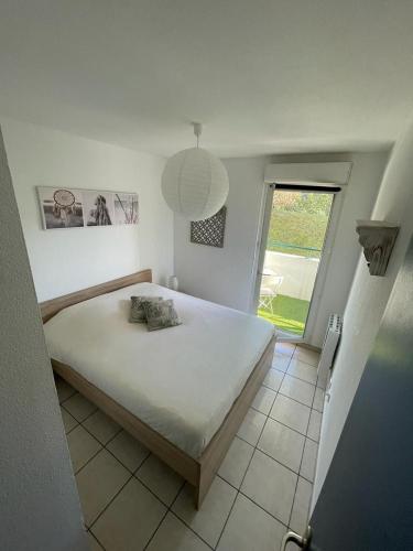 une chambre avec un grand lit et une fenêtre dans l'établissement ZenBNB / Léman / Garage /Balcon/ Piscine, à Annemasse