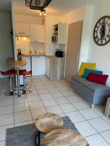 un salon avec un canapé et une table et une cuisine dans l'établissement ZenBNB / Léman / Garage /Balcon/ Piscine, à Annemasse