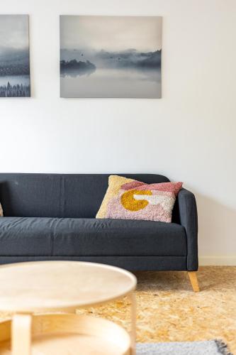 a living room with a black couch and a table at Le Gîtel in Spa